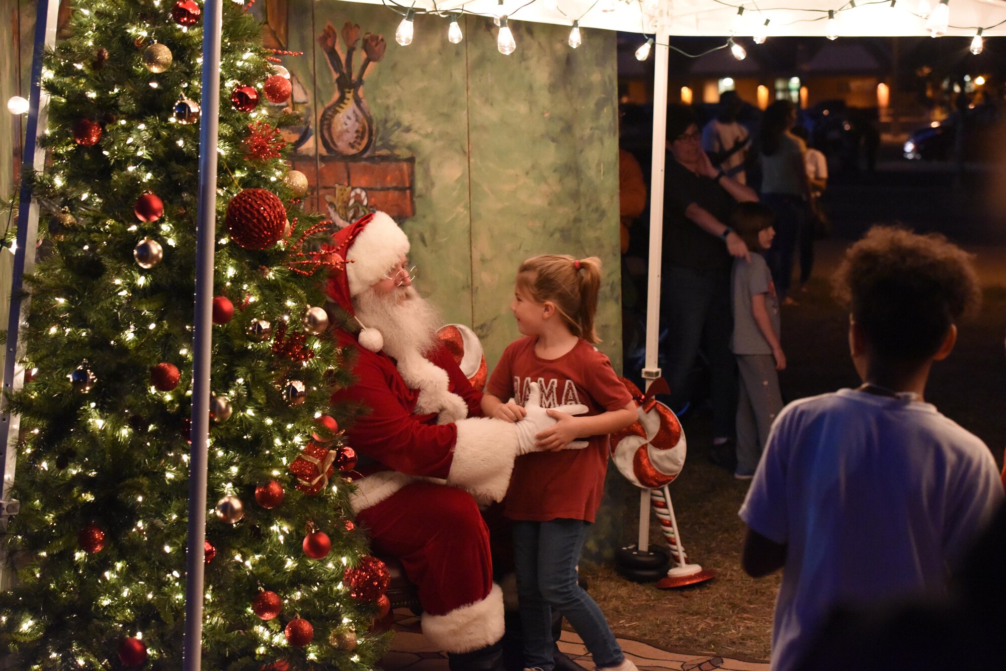 A child sits on Santa Claus’ lap and lets him know what they wants for Christmas during the Tree Lighting Ceremony at the Parade Field on Goodfellow Air Force Base, Texas, Dec. 4, 2017. The line for Santa lasted long after the main event ended as children waited their turn. (U.S. Air Force photo taken by Airman 1st Class Zachary Chapman/Released)