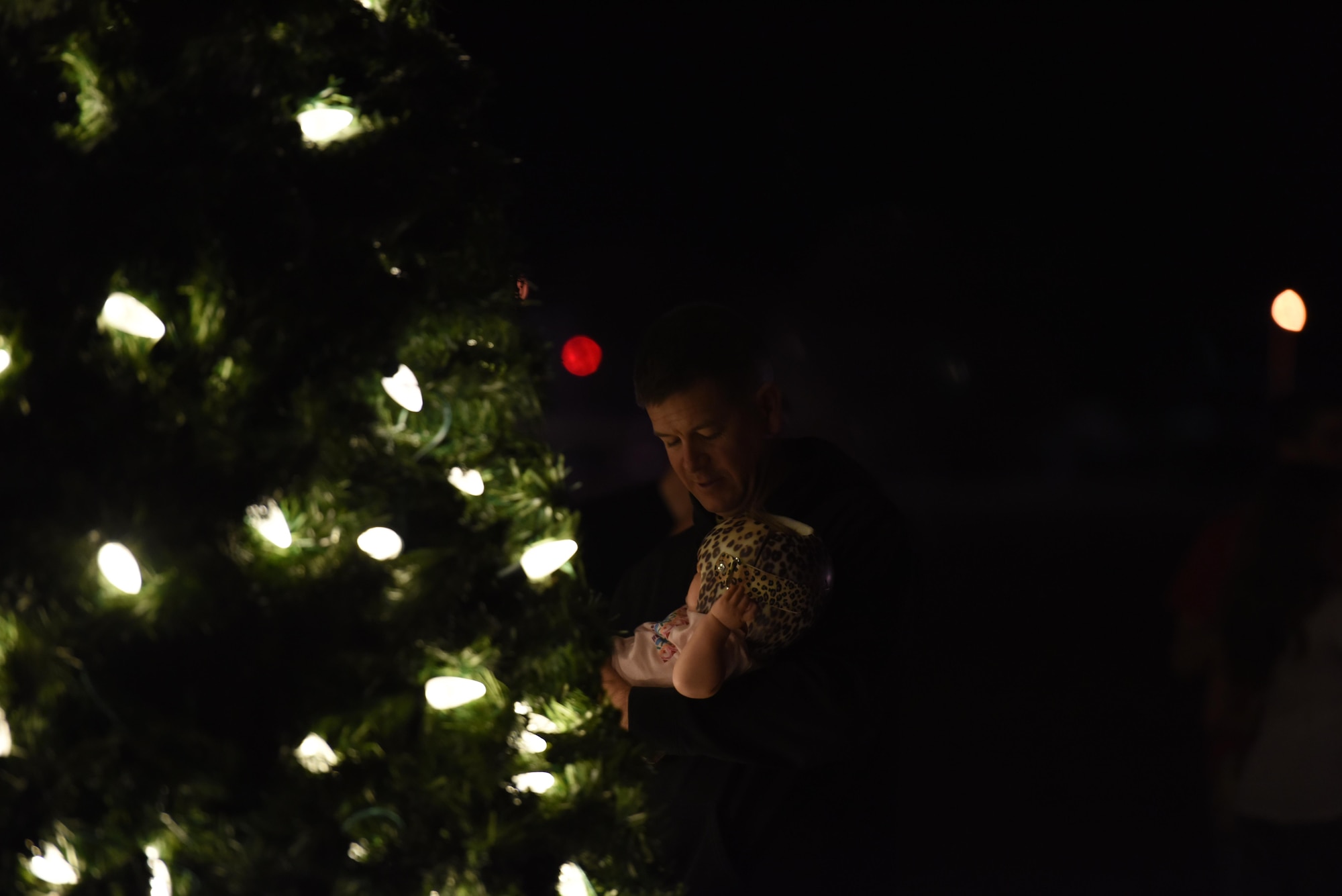 U.S. Marine Corp. Maj. Andrew Armstrong, Marine Corp. Detachment commanding officer, holds a baby during the Tree Lighting Ceremony at the Parade Field on Goodfellow Air Force Base, Texas, Dec. 4, 2017. The event held activities for children such as making decorations or cookies as well as Olaf from the Disney movie Frozen, U.S. Air Force Col. Jeffrey Sorrell, 17th Training Wing vice commander, and Santa Claus. (U.S. Air Force photo by Airman 1st Class Zachary Chapman/ Released)