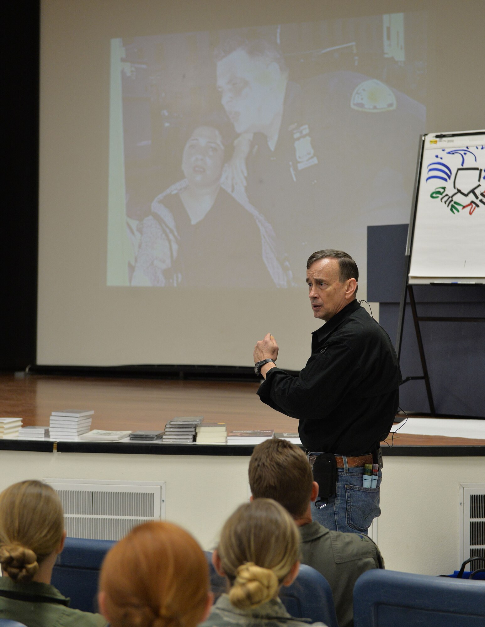 Retired Lt. Dave Col. Grossman refers to a photograph taken during the 9/11 terrorist attack to express what stress does to the human body Nov. 13, 2017, at Creech Air Force Base, Nev. Grossman is a public speaker who focuses on the effects of combat and living a life of sacrifice. (U.S. Air Force Photo by Airman 1st Class Haley Stevens)