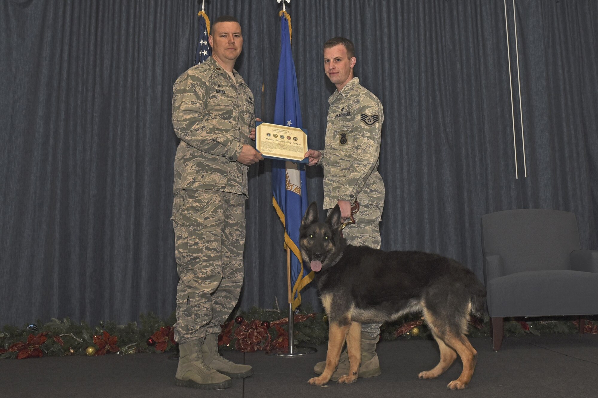 Military Working Dog Oxigen receives a certificate of Meritorious Service Nov. 30, 2017, at Fairchild Air Force Base, Washington. Oxigen retired after eight years of dedicated military service as a patrol explosive detection dog. She devoted more than 207 hours conducting explosive sweeps, U.S. Secret Service support and Department of State coverage for multiple dignitaries. (U.S. Air Force photo/Airman Whitney Laine)
