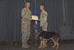 Military Working Dog Oxigen receives a certificate of Meritorious Service Nov. 30, 2017, at Fairchild Air Force Base, Washington. Oxigen retired after eight years of dedicated military service as a patrol explosive detection dog. She devoted more than 207 hours conducting explosive sweeps, U.S. Secret Service support and Department of State coverage for multiple dignitaries. (U.S. Air Force photo/Airman Whitney Laine)