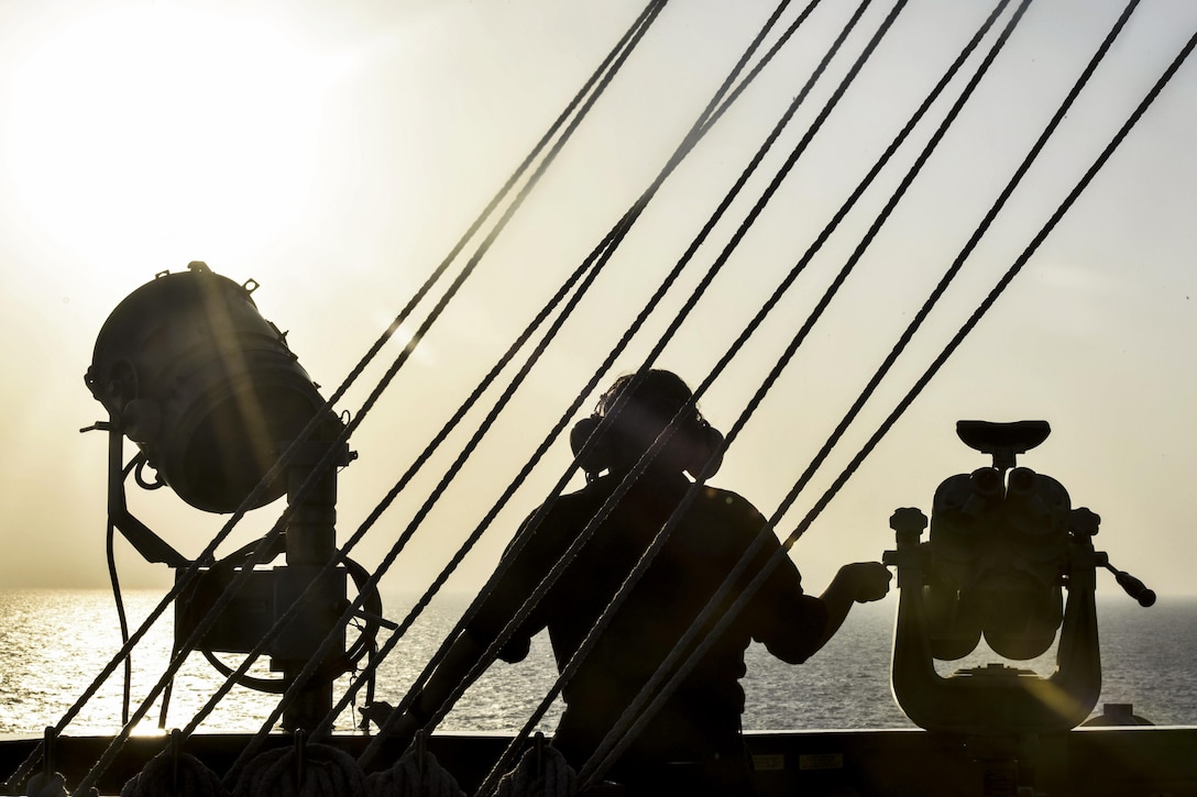 A sailor stands watch on a ship in the Persian Gulf.