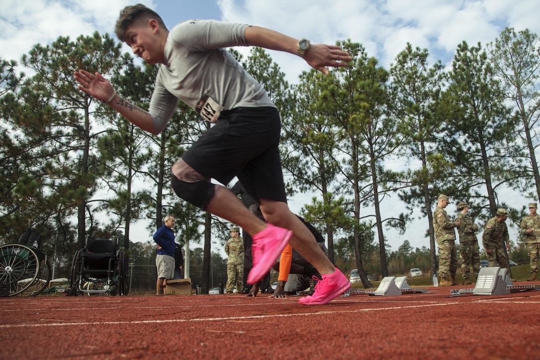 A soldier in pink running shoes practices for a track event.