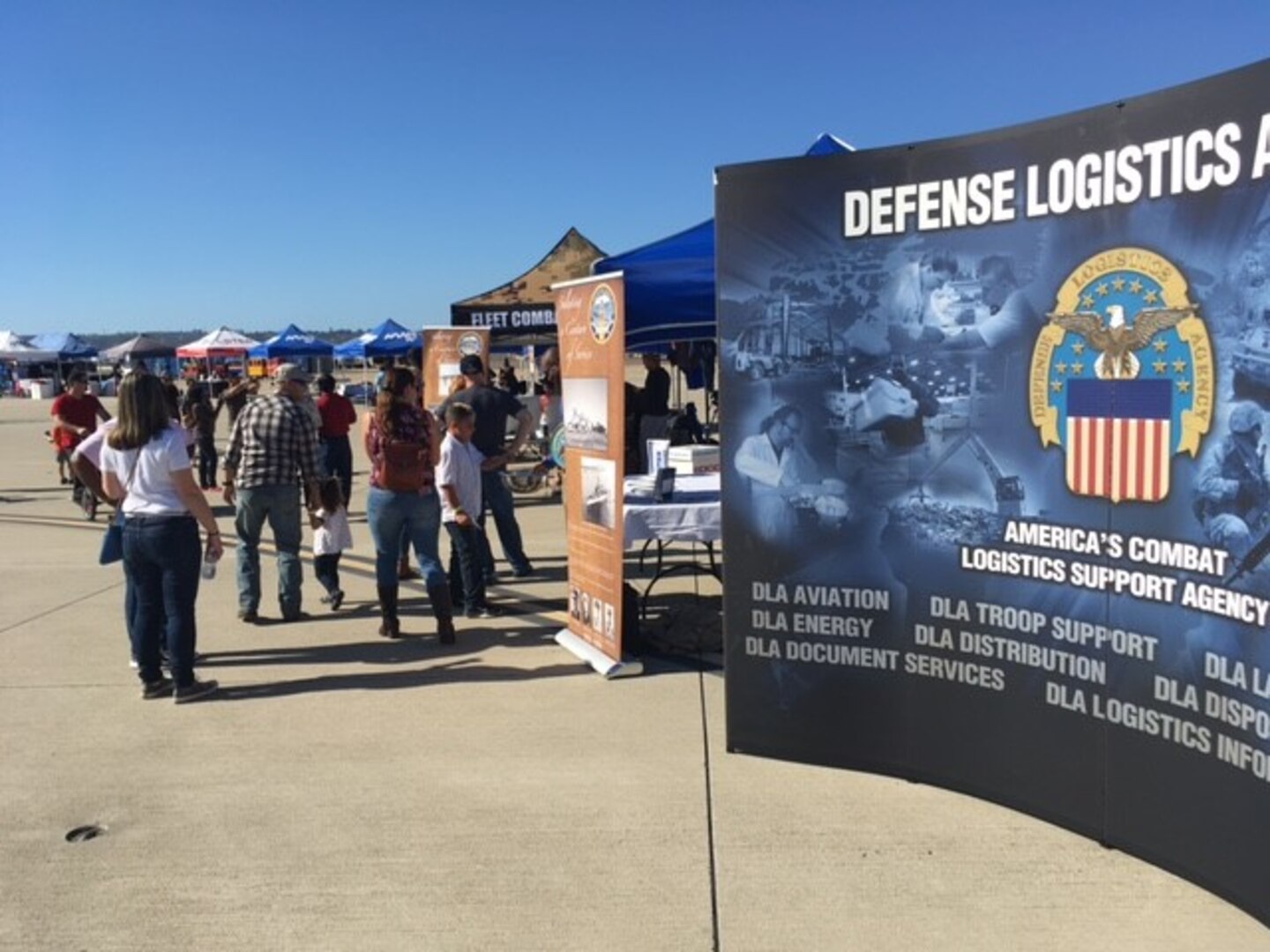 Service members, retirees, family members and guests visit the DLA Tent during the Naval Air Station North Island Centennial Celebration, on Nov. 11, 2017.