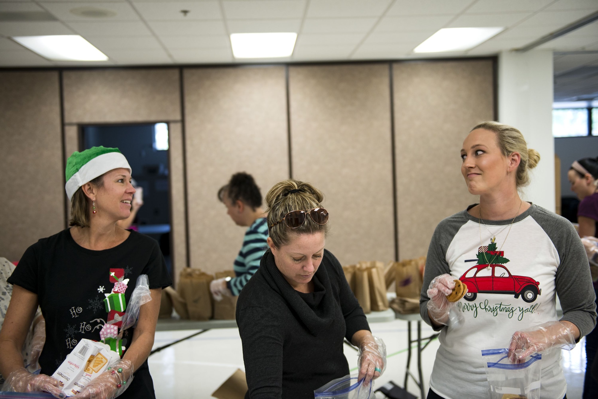 Marcie Chastain, left, Rena Hall, and Elaine McPherson, Team Moody military spouses, pack cookies into bags during the Annual Moody Airmen Cookie Drive, Dec. 4, 2017, at Moody Air Force Base, Ga. Local organizations, Airmen and spouses donated more than 8,000 cookies to approximately 700 dorm residents to show appreciation for the Airmen during the holidays. (U.S. Air Force photo by Airman 1st Class Erick Requadt)