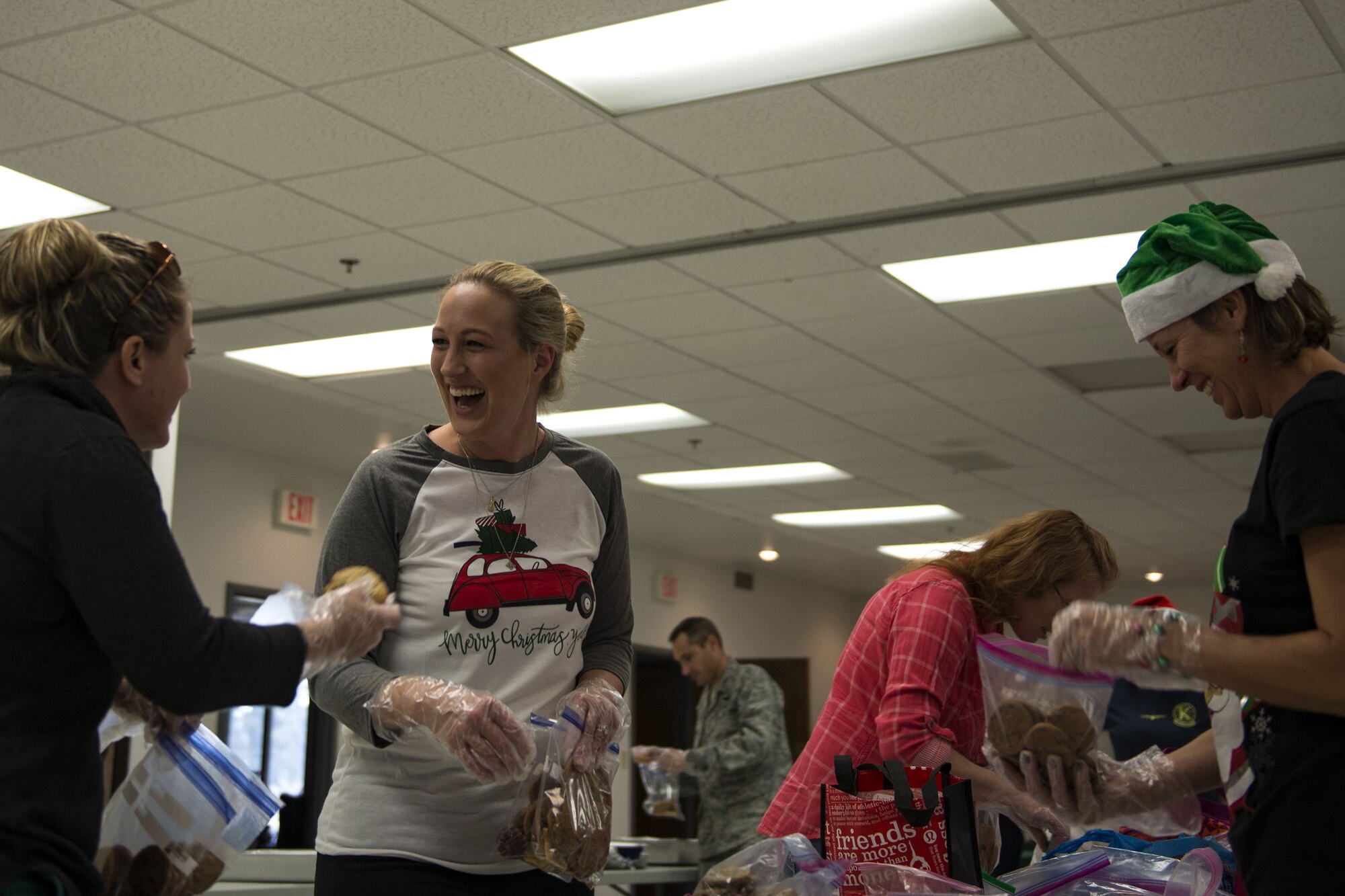 Team Moody spouses share a laugh while packing cookies during the Annual Moody Airmen Cookie Drive, Dec. 4, 2017, at Moody Air Force Base, Ga. Local organizations, Airmen and spouses donated more than 8,000 cookies to approximately 700 dorm residents to show appreciation for the Airmen during the holidays. (U.S. Air Force photo by Airman 1st Class Erick Requadt)