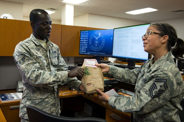 Senior Master Sgt. Regina Dockens, right, 23d Communications Squadron first sergeant, gives a bag of cookies to Airman 1st Class Theophilus Agyare, 23d Contracting Squadron contracting specialist, during the Annual Moody Airmen Cookie Drive, Dec. 5, 2017, at Moody Air Force Base, Ga. Local organizations, Airmen and spouses donated more than 8,000 cookies to approximately 700 dorm residents to show appreciation for the Airmen during the holidays. (U.S. Air Force photo by Airman 1st Class Erick Requadt)