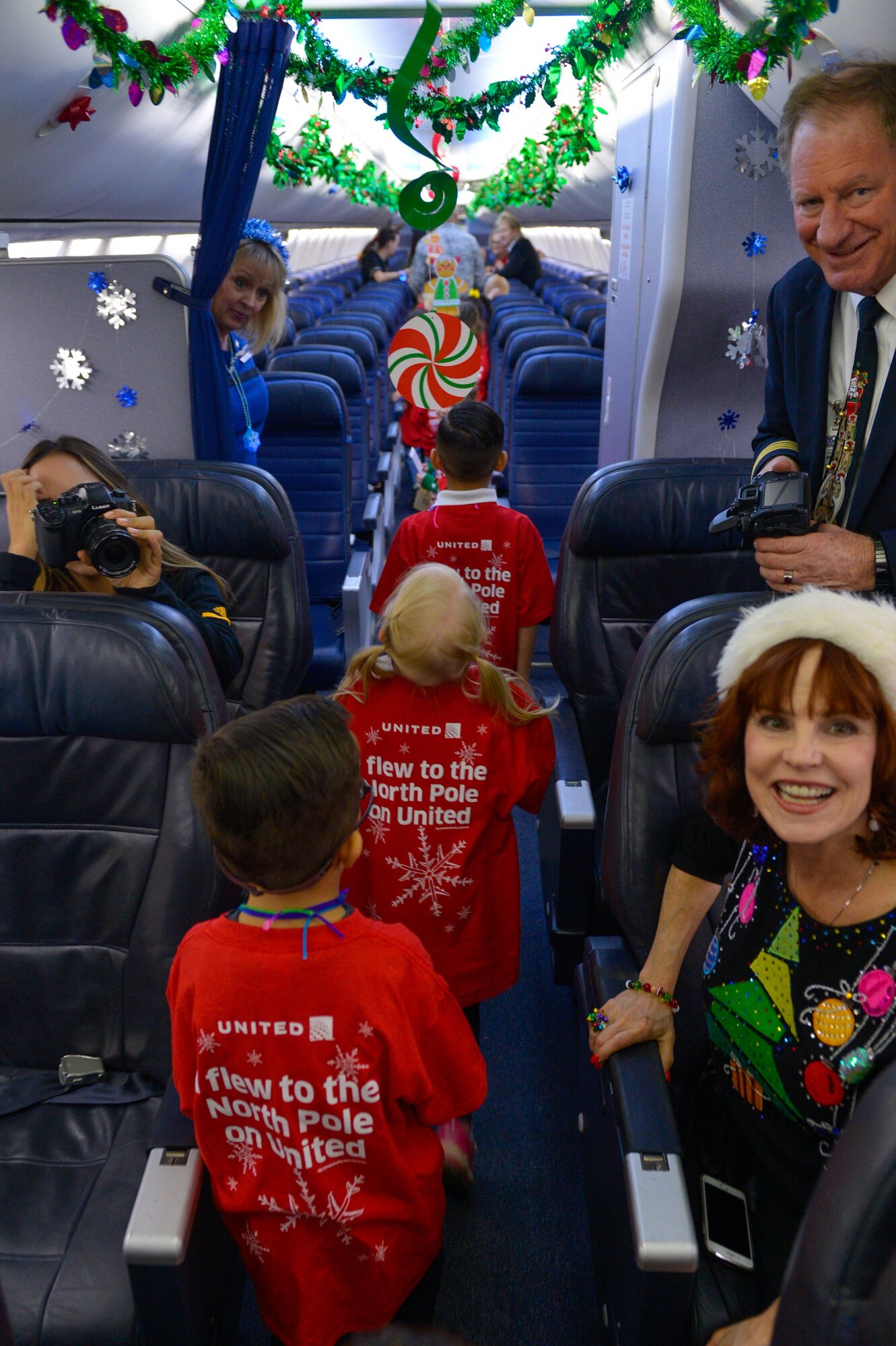 Children from Luke Air Force Base board a holiday-themed plane during the United Fantasy Flight at the Phoenix Sky Harbor International Airport in Phoenix Ariz., Dec. 1, 2017. The flight landed at a nearby hangar that had been transformed into the North Pole. (U.S. Air Force photo/Senior Airman Devante Williams)