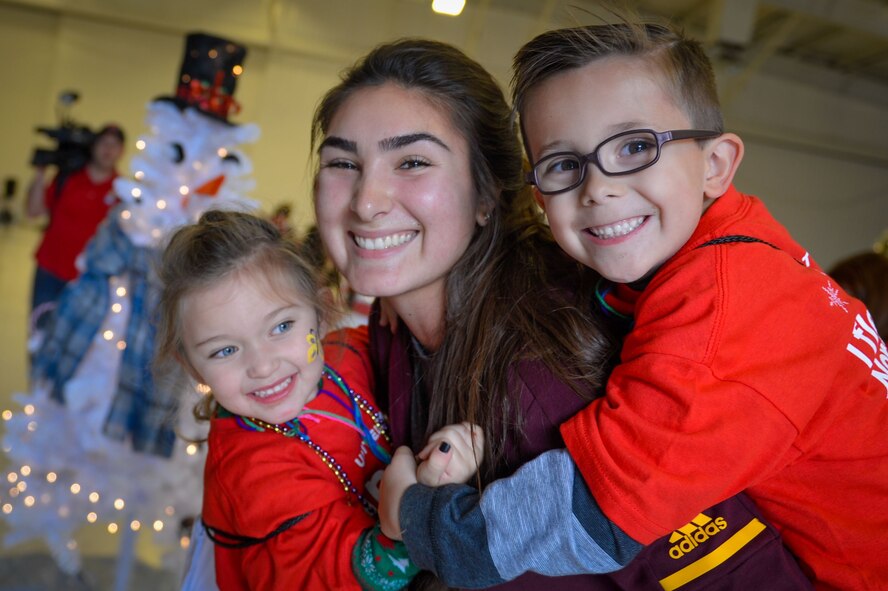 Aria Hueso, Arizona State University water polo athlete, poses with Team Luke children, during the United Fantasy Flight at the Phoenix Sky Harbor International Airport in Phoenix Ariz., Dec. 1, 2017. United Airlines invited children from Luke whose parents are currently deployed to attend the special event. (U.S. Air Force photo/Senior Airman Devante Williams)