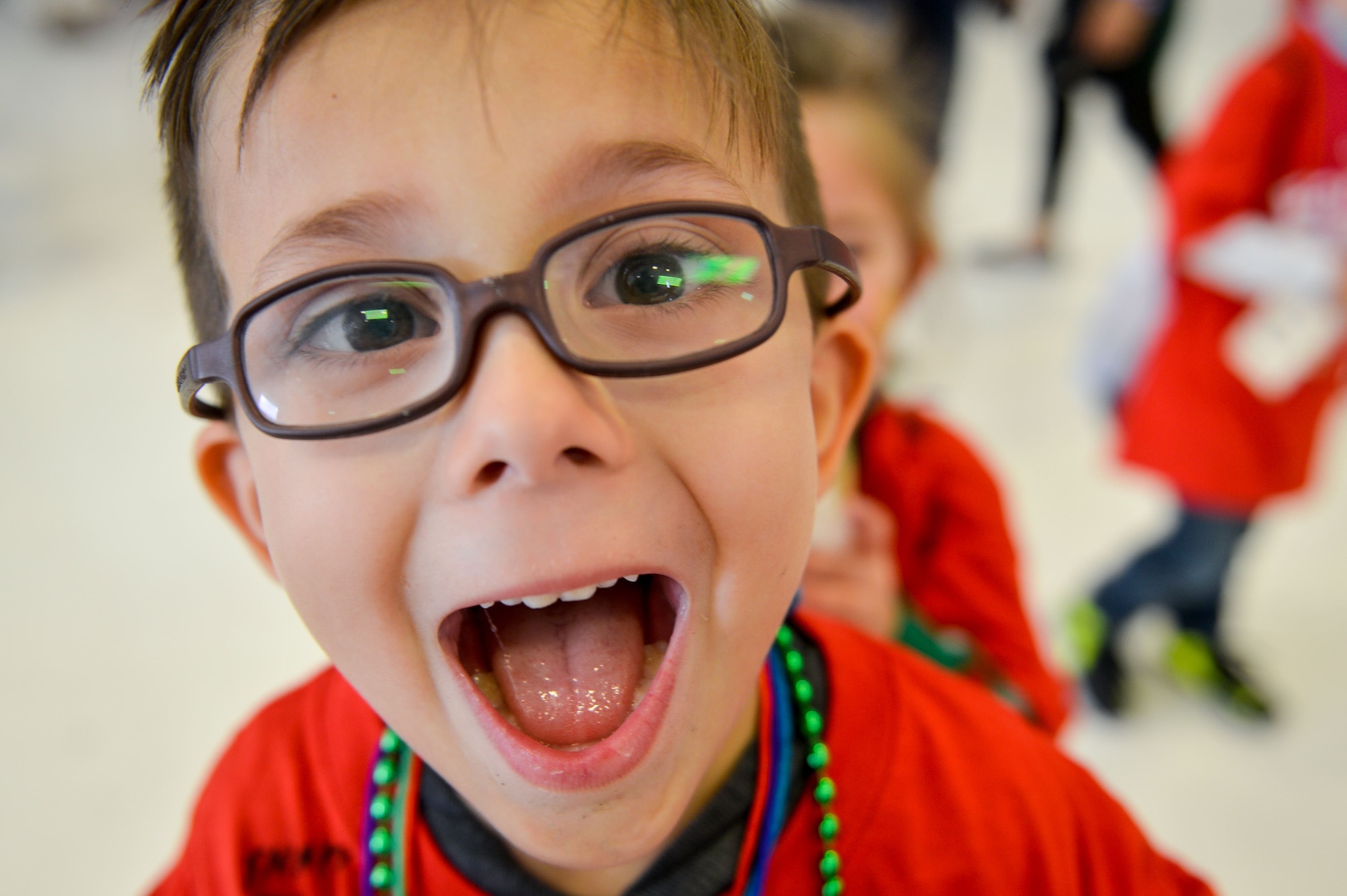 A Team Luke child smiles during the United Fantasy Flight at the Phoenix Sky Harbor International Airport in Phoenix Ariz., Dec. 1, 2017. Several children from Luke, who have a family member currently deployed, were invited to the special event where they received shoes, sweatshirts, blankets, toys, books and a tablet. (U.S. Air Force photo/Senior Airman Devante Williams)