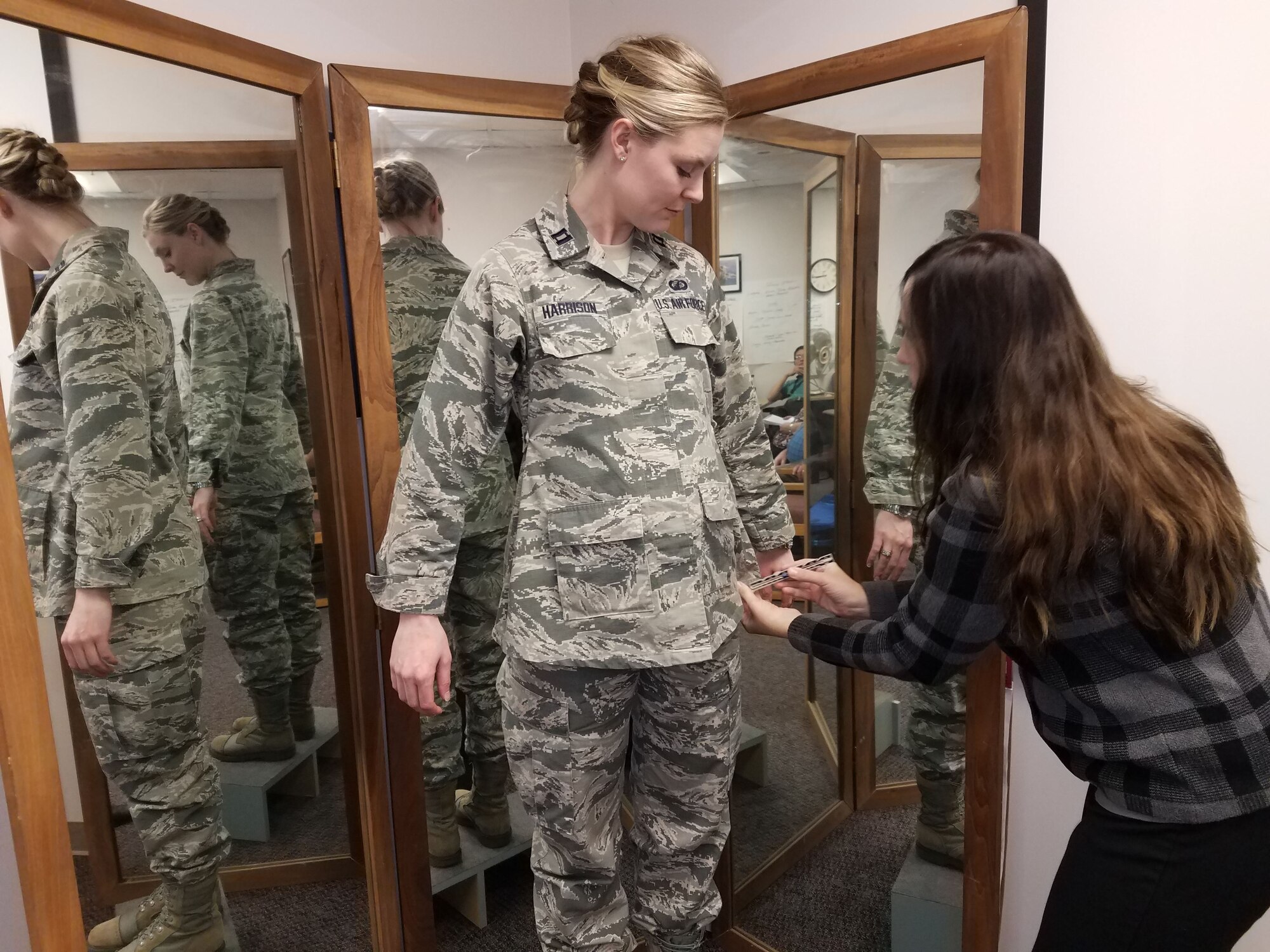 Stacey Butler (right) a clothing designer with the Air Force Life Cycle Management Center's Air Force Uniform Office, measures Capt. Taylor Harrison's maternity Airman Battle Uniform. The new uniforms were designed and developed by the office and are available to pregnant Airmen around the world. ( U.S. Air Force photo / Brian Brackens)