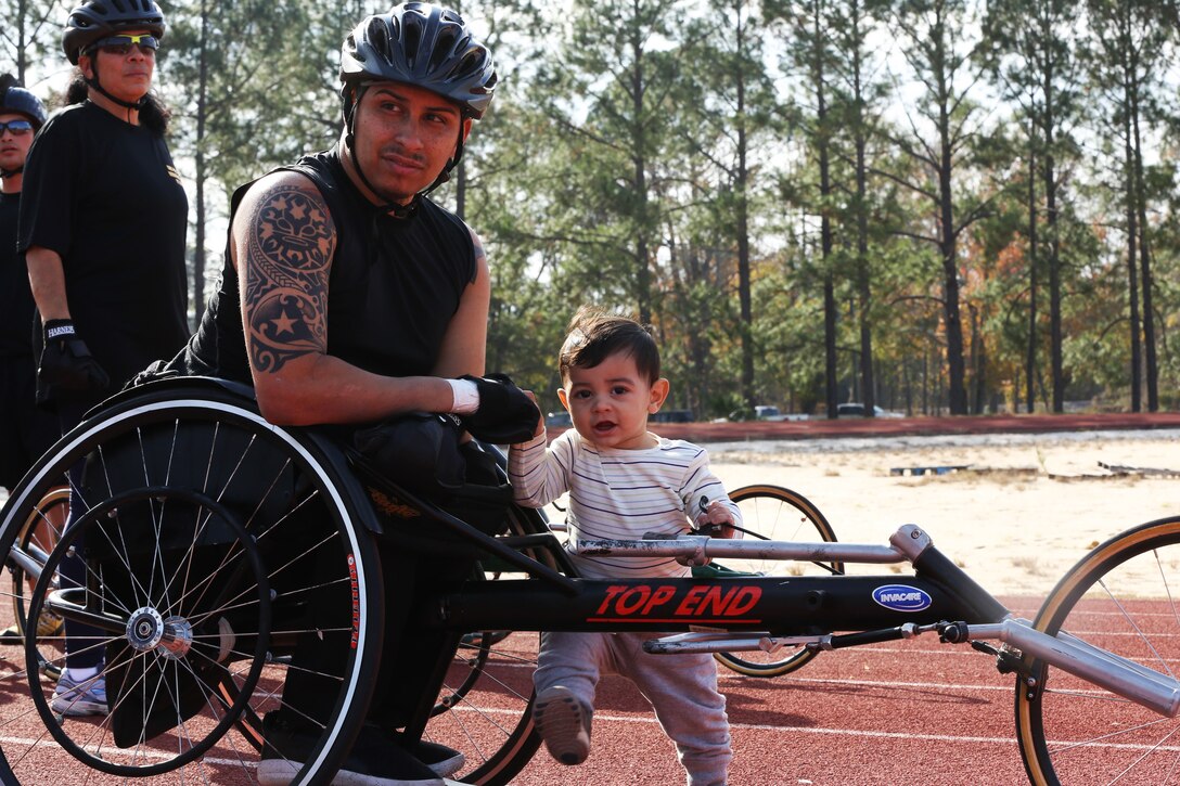 A soldier waits with his son for the Warrior Games Regional trials to start