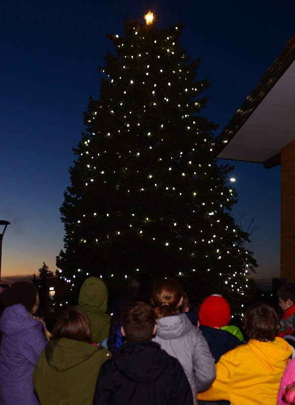 Ellsworth family members gather around The Freedom Chapel Christmas tree during the Base Holiday Tree Lighting Ceremony at Ellsworth Air Force Base, S.D., Dec. 1, 2017. Children of deployed Airmen joined both Col. John Edwards, the 28th Bomb Wing commander, and Chief Master Sgt. Adam Vizi, the 28th BW command chief, in flipping a switch to light up the Christmas tree. (U.S. Air Force photo by Airman 1st Class Donald C. Knechtel)