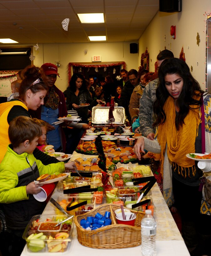 Airmen and their families enjoy a holiday feast during the Base Holiday Tree Lighting Ceremony at Ellsworth Air Force Base, S.D., Dec. 1, 2017. The 28th Bomb Wing Chaplain Corps hosts this event annually to bring the base community together during the holiday season. (U.S. Air Force photo by Airman 1st Class Donald C. Knechtel)