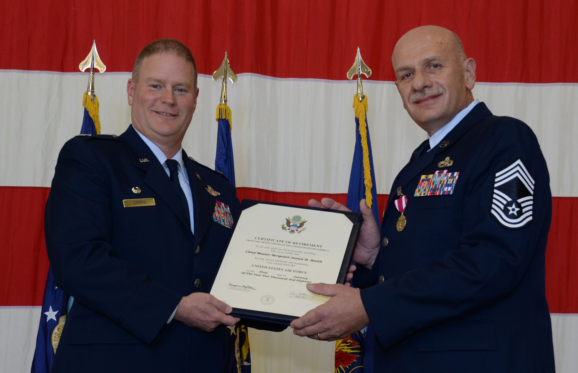 Col. James DeVere, commander of the 302nd Airlift Wing, presents a certificate of retirement to Chief Master Sgt. James Smith, superintendent of the 302nd Maintenance Group, during his retirement ceremony in Hangar 210 at Peterson AFB, Colo., Dec. 2, 2017. Smith is retiring after 30 years of service to the Air Force -- 20 of which were dedicated to maintaining the Reserve wing’s C-130 Hercules aircraft. “I know I’m leaving my Air Force in great hands,” Smith said to those attending his ceremony. “Because of you, because you’re ready, I can tell you that I am retiring confidently.” (U.S. Air Force photo/Staff Sgt. Justin Norton)