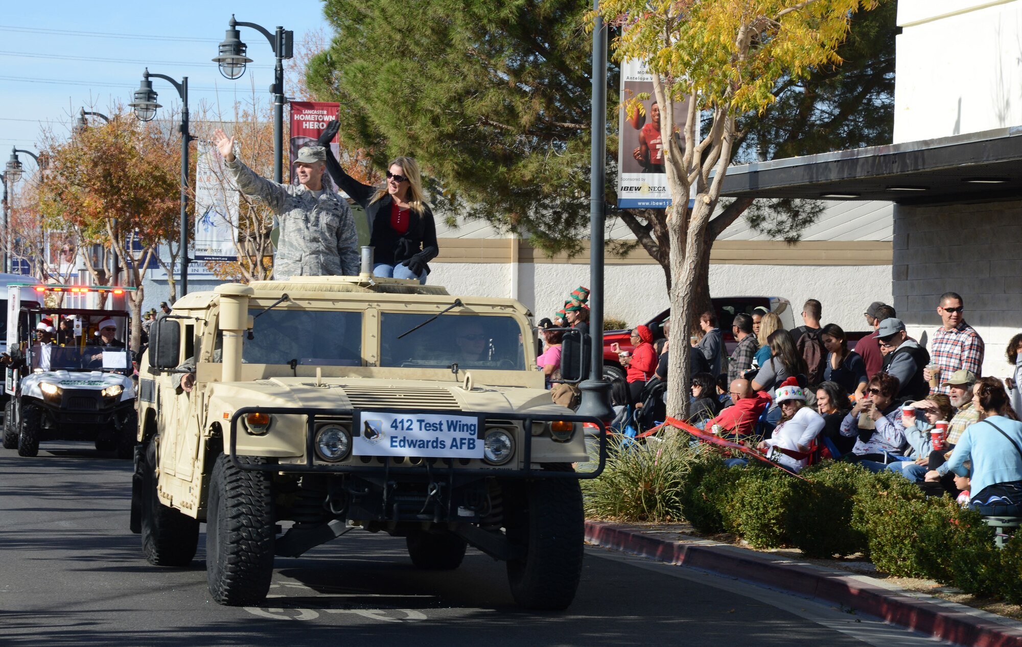Col. Norman West, commander of the 412th Medical Group,  and his wife Michelle greet the crowds on Lancaster Boulevard during the Lancaster Christmas Parade Dec. 2.
Driving the Humvee is Senior Airman Nathan Dunn, an explosive ordnance technician with the 812th Civil Engineer Group. (U.S. Air Force photo by Christopher Ball)