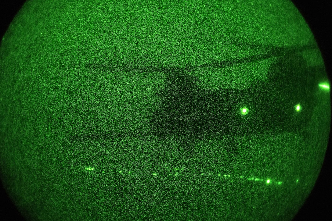 A CH-47 Chinook helicopter is seen through a night-vision device.