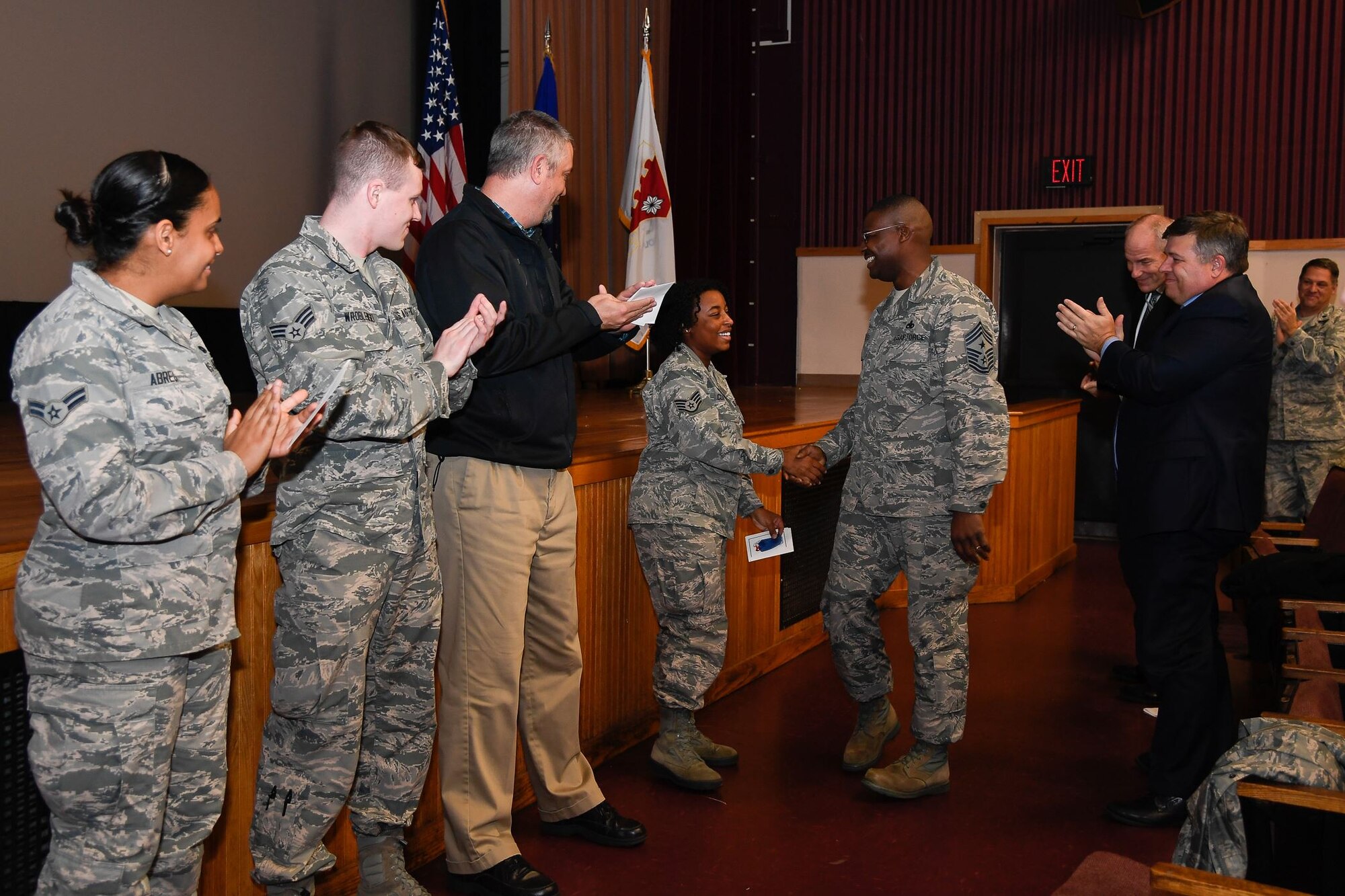 Chief Master Sgt. Henry L. Hayes, Jr., Hanscom command chief, congratulates Staff Sgt. Amber Clayton, 66th Medical Squadron Mental Health technician, on her commissioning notification for officer training school during an Air Base Group commander’s call at the base theater Dec. 5.