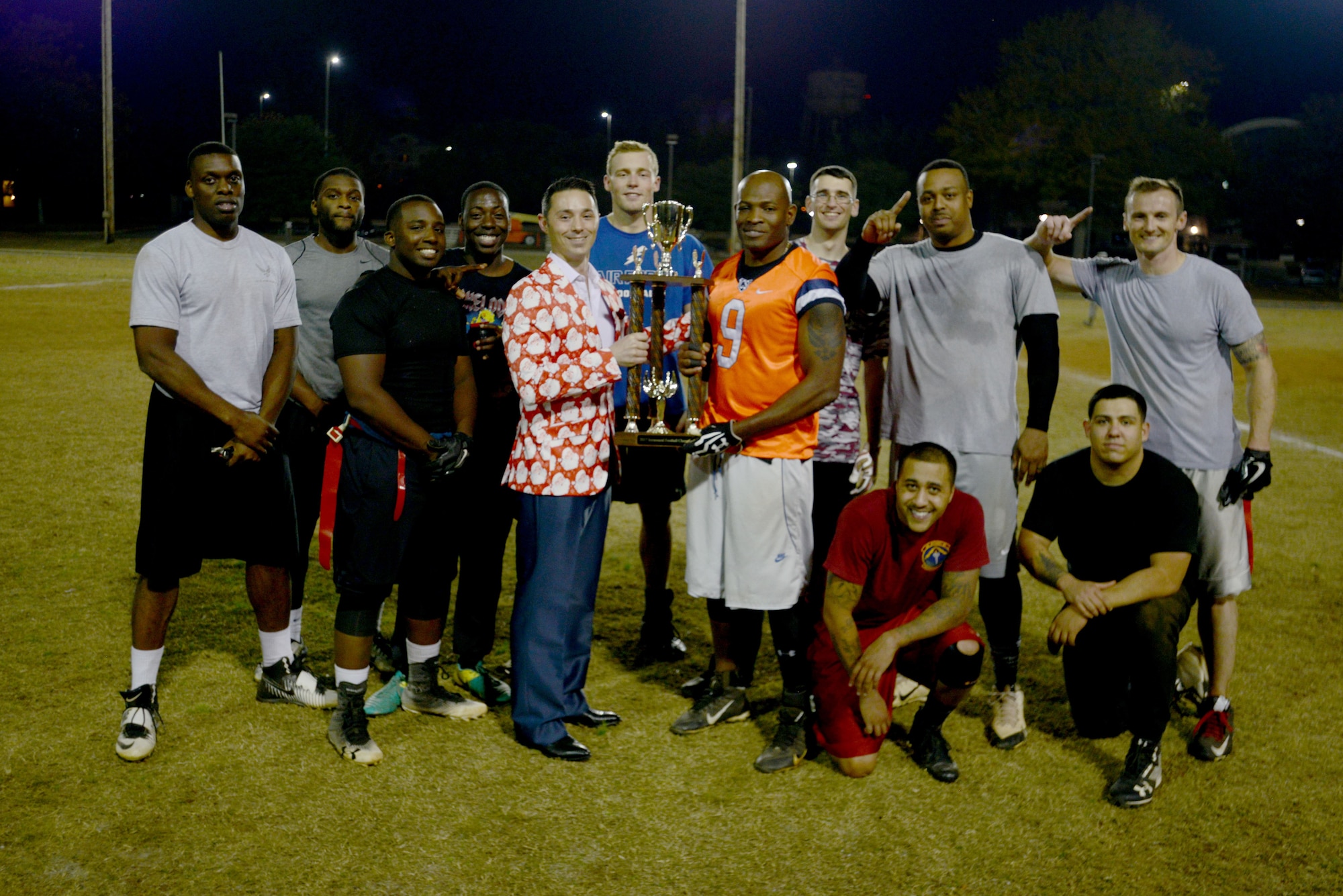 Members of the U.S. Air Forces Central (AFCENT) flag football team surround their trophy at Shaw Air Force Base, S.C. Dec.1, 2017.