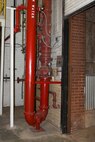 Red-painted fire-suppression pipes are shown near an opened vertical roll-up door in Bldg. 3001 on Nov. 17, 2017, Tinker Air Force Base, Oklahoma. Areas like this have a higher potential for proximity freezing if not monitored closely and doors aren't closed to keep the heat in during below-freezing periods.