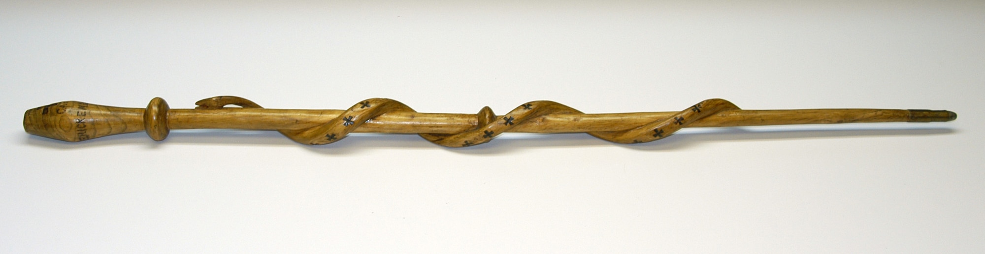 This wooden swagger stick was made in France for Captain E.V. Rickenbacker during his service in World War I. Spiraling up the surface of the stick is a carved wooden snake marked down the back with 26 black German Crosses-representing Rickenbacker's 26 aerial victories over his German opponents.