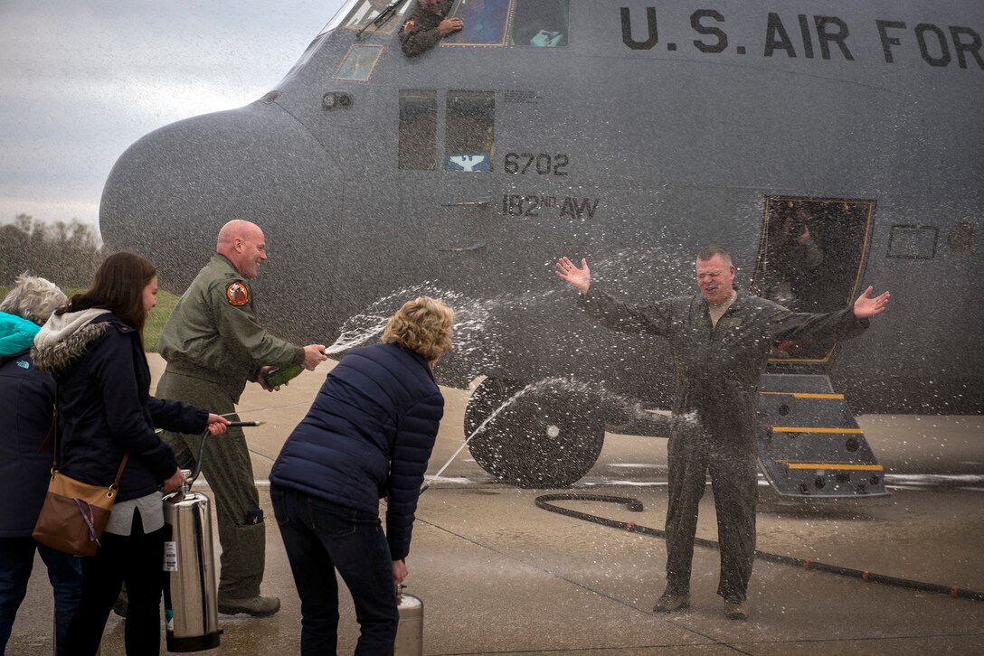 The family and coworkers of U.S. Air Force Col. William Robertson, the commander of the 182nd Airlift Wing, Illinois Air National Guard, showers him with water and champagne upon his arrival from his final C-130 Hercules flight in Peoria, Ill., Oct. 31, 2017. Robertson commanded the wing for 13 years before his promotion to brigadier general and appointment to the role of chief of staff of the Illinois Air National Guard in November 2017. (U.S. Air National Guard photo by Tech. Sgt. Lealan Buehrer)