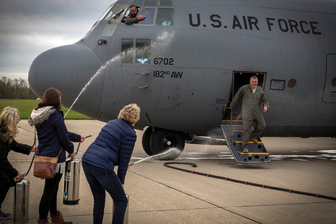 The family of U.S. Air Force Col. William Robertson, the commander of the 182nd Airlift Wing, Illinois Air National Guard, showers him with water and champagne upon his arrival from his final C-130 Hercules flight in Peoria, Ill., Oct. 31, 2017. Robertson commanded the wing for 13 years before his promotion to brigadier general and appointment to the role of chief of staff of the Illinois Air National Guard in November 2017. (U.S. Air National Guard photo by Tech. Sgt. Lealan Buehrer)