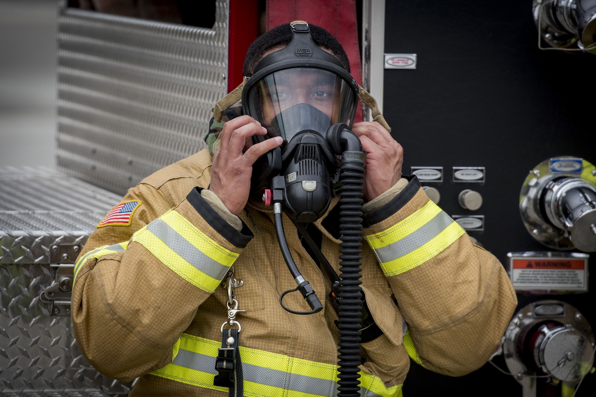 A 374th Civil Engineer Squadron firefighter prepares to remove his gas mask during exercise Beverly Morning 17-08 in conjunction with exercise Vigilant Ace 18, Dec. 4, 2017, at Yokota Air Base, Japan.