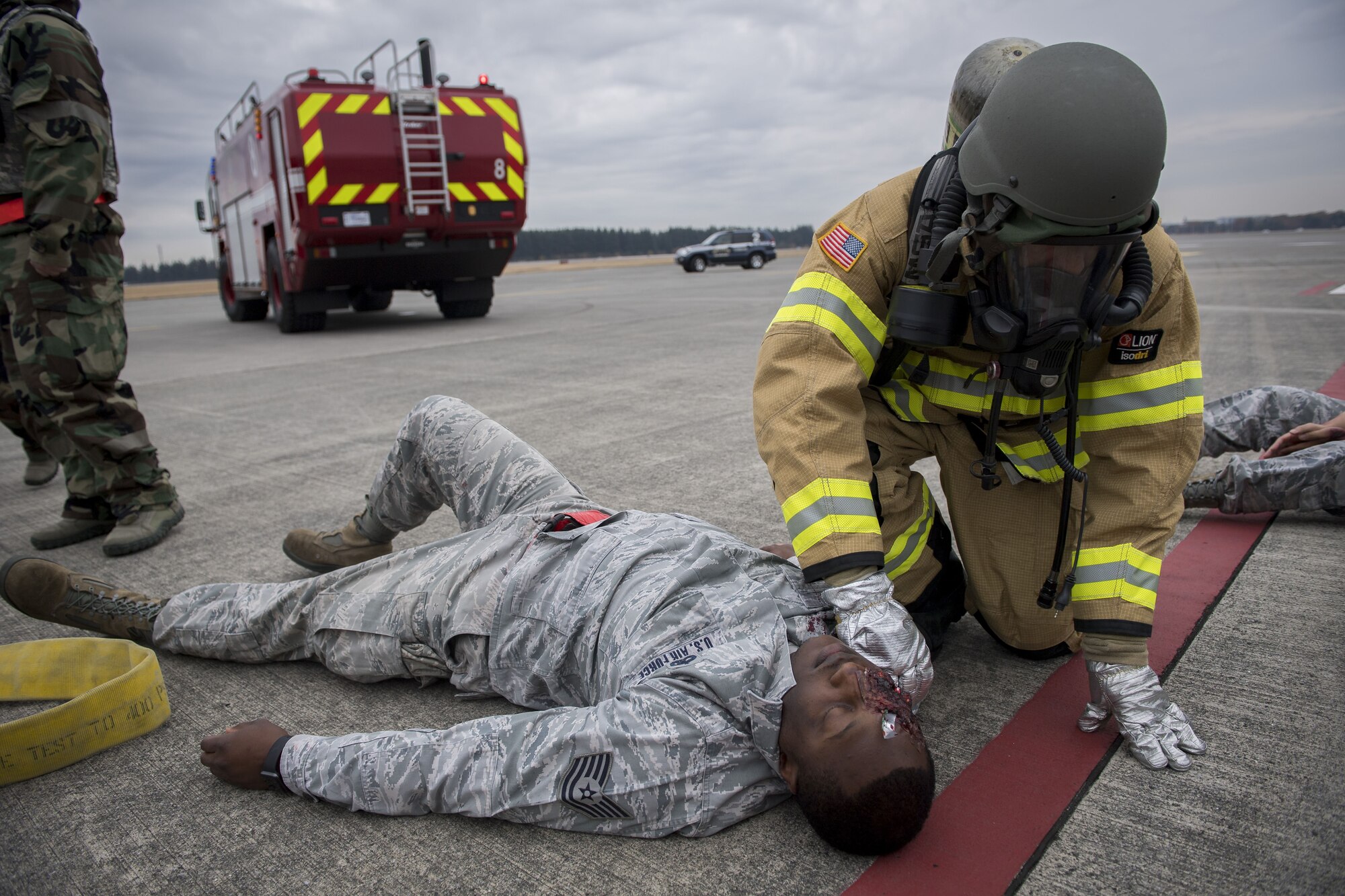 A 374th Civil Engineer Squadron firefighter checks on the status of a simulated injured service member during exercise Beverly Morning 17-08 in conjunction with exercise Vigilant Ace 18, Dec. 4, 2017, at Yokota Air Base, Japan.