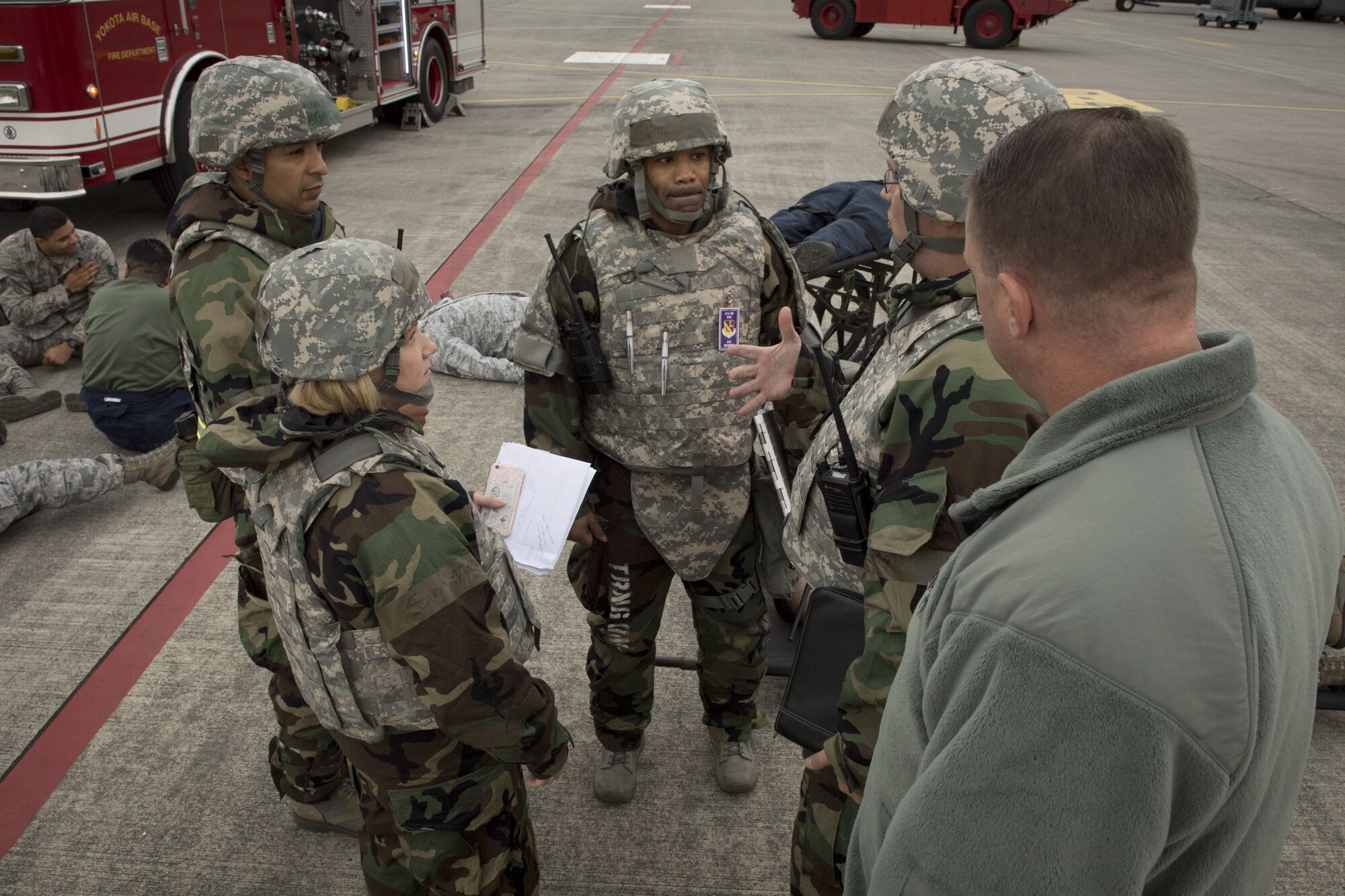 Members of the Wing Inspection Team discuss the outcome of the emergency response of a simulated missile attack on the flight line during exercise Beverly Morning 17-08 in conjunction with exercise Vigilant Ace 18, Dec. 4, 2017, at Yokota Air Base, Japan.