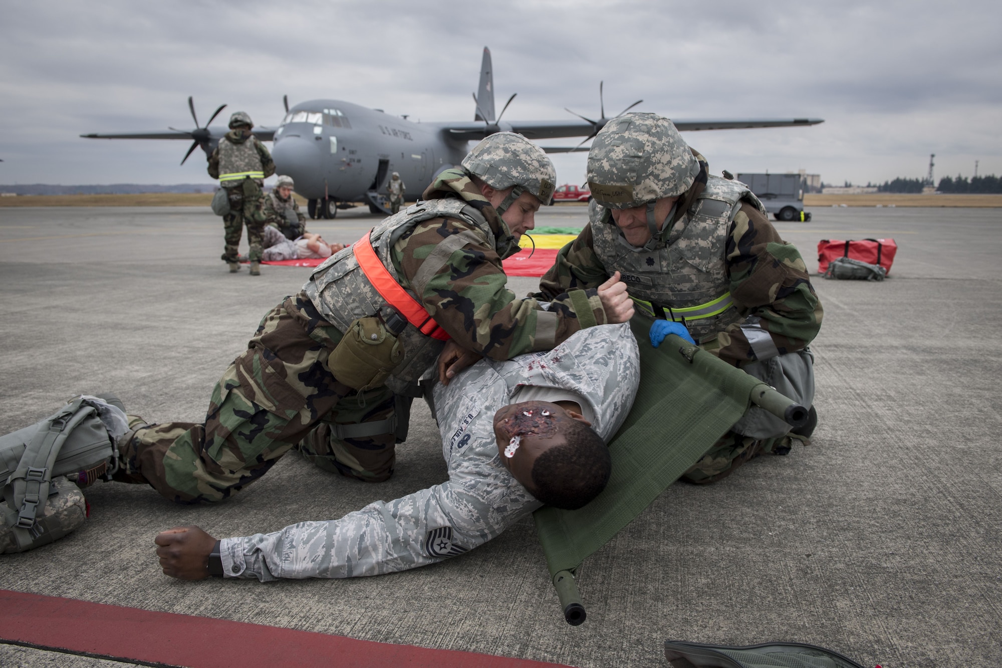 A 374th Medical Squadron medic and on scene doctor work together to place a simulated victim on a stretcher during exercise Beverly Morning 17-08 in conjunction with exercise Vigilant Ace 18, Dec. 4, 2017, at Yokota Air Base, Japan.