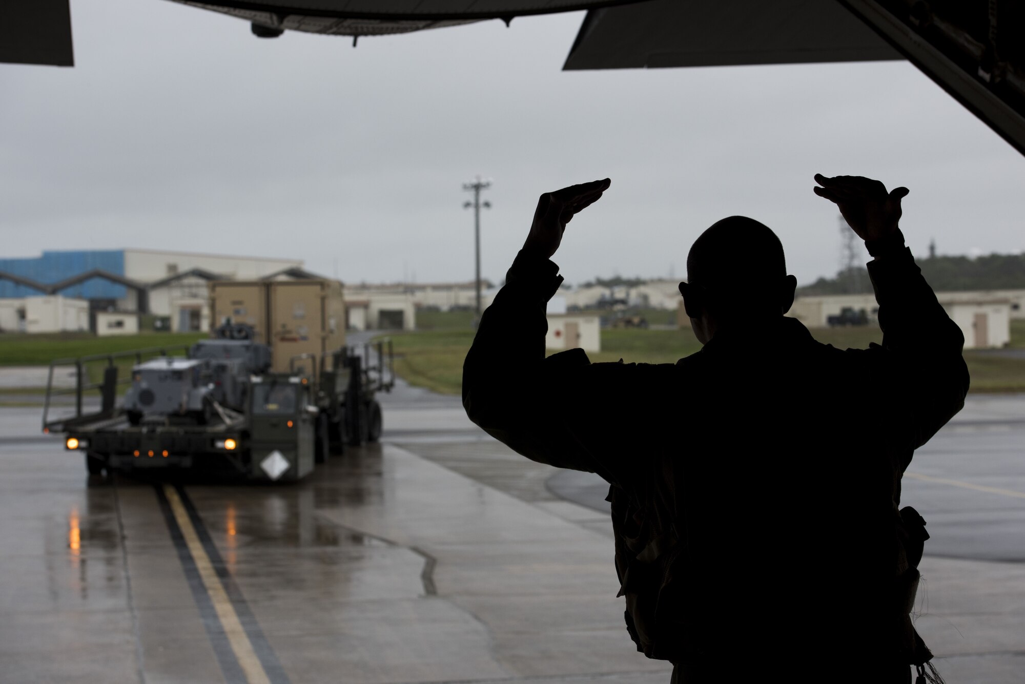 Tech Sgt. Gary Woolridge, 40th Airlift Squadron C-130J Super Hercules loadmaster, guides an equipment operator to load cargo in preparation for exercise Vigilant Ace 18 on C-130J, Dec. 1, 2017, at Kadena Air Base, Japan.