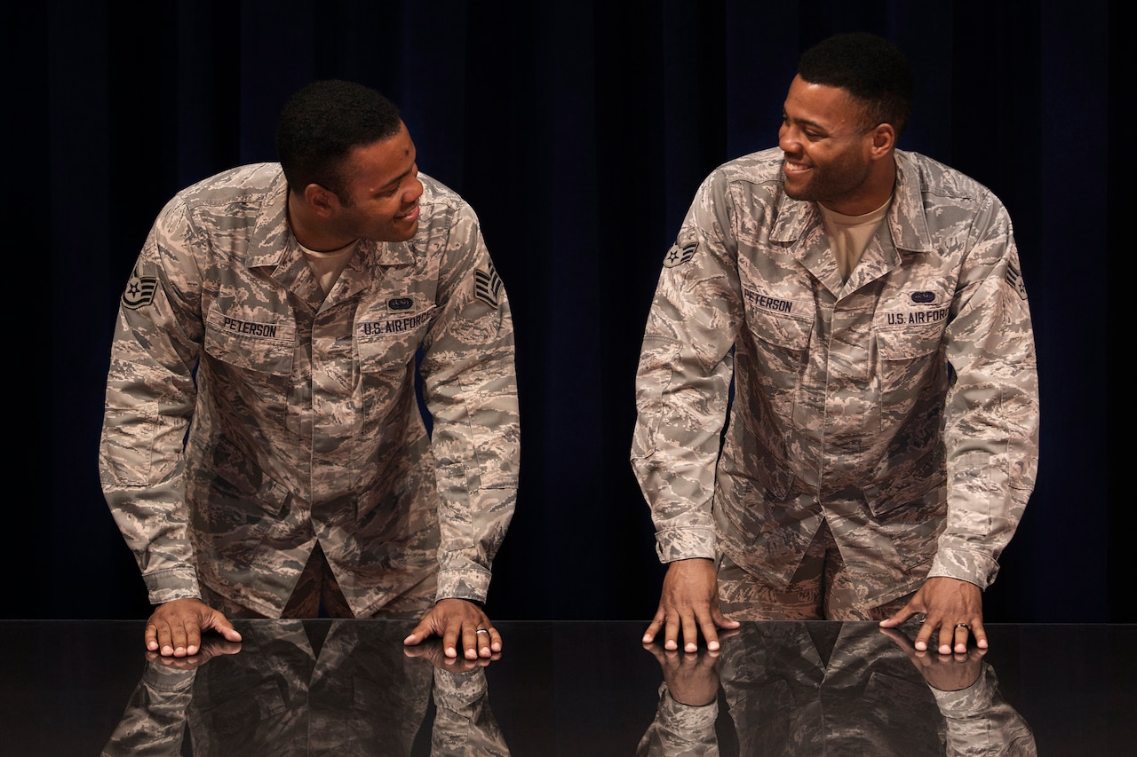 Staff Sgt. Jordan Peterson (left) smiles at his twin brother, Senior Airman Jarrod Peterson during a photo shoot at Patrick AFB, Fla.  Both Airmen are stationed at the Air Force Technical Applications Center as web developers for AFTAC’s Cyber Capabilities Squadron. (U.S. Air Force photo by Matthew S. Jurgens)