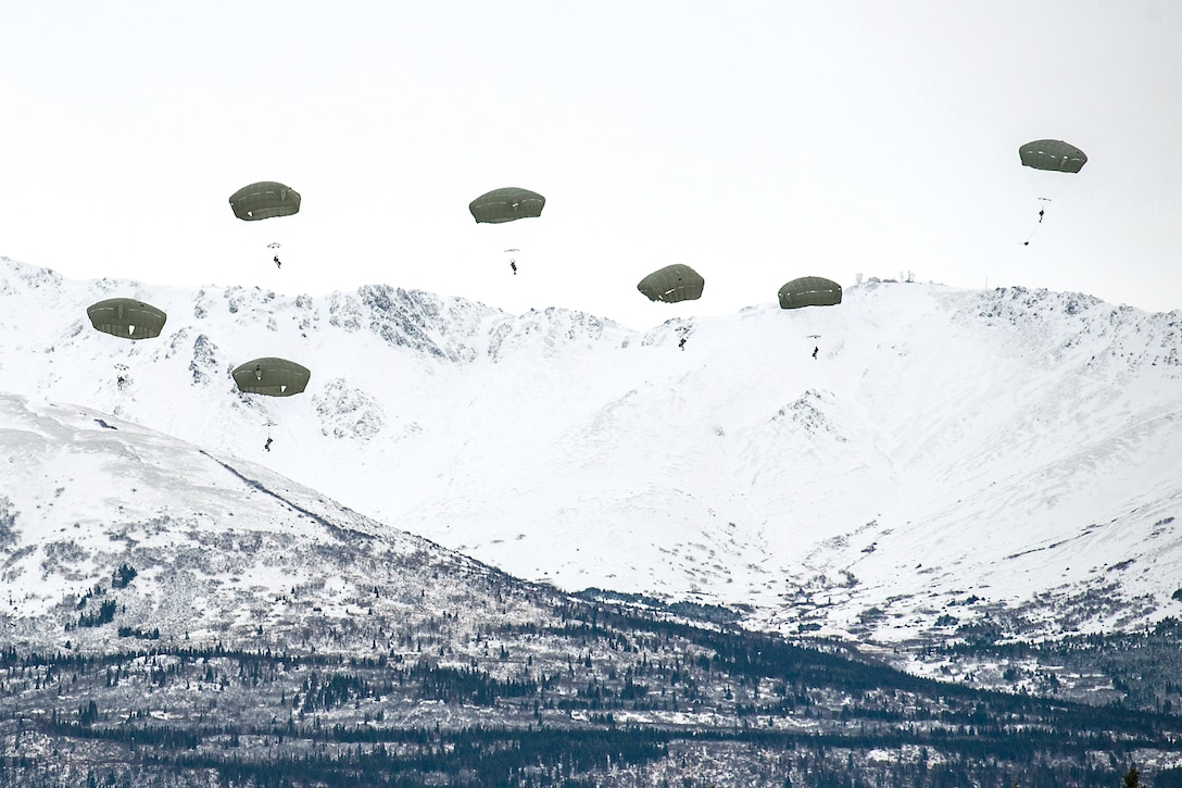 Soldiers descend to the drop zone after jumping from a C-17 Globemaster III aircraft.