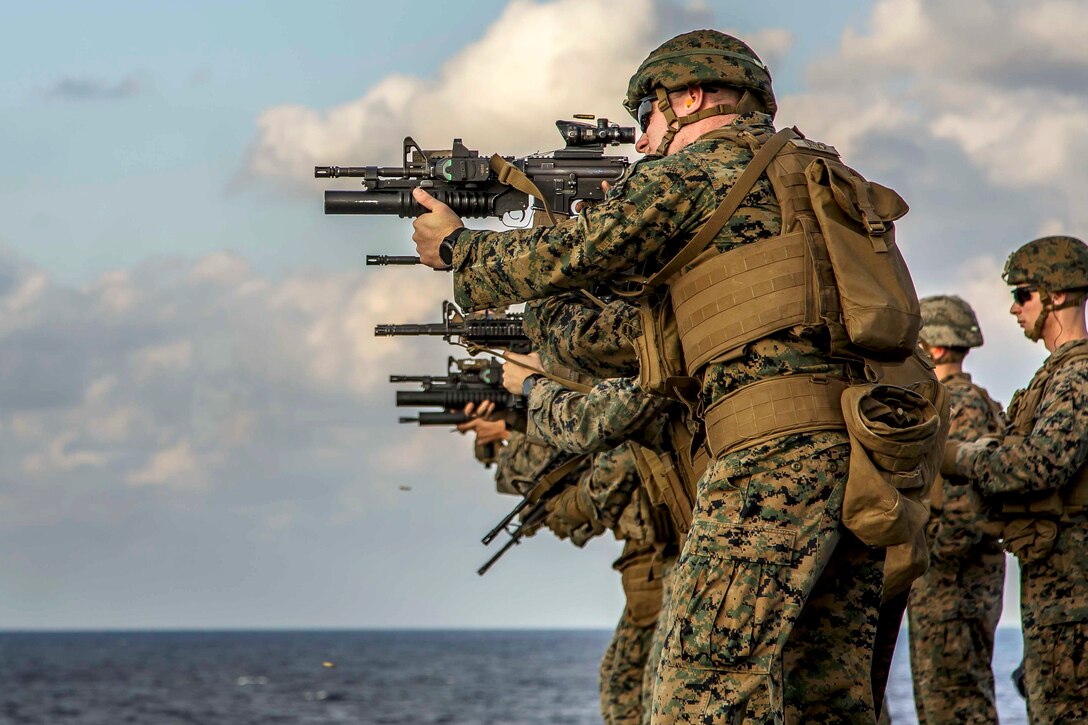 Marines fire their weapons engaging targets during combat marksmanship training.