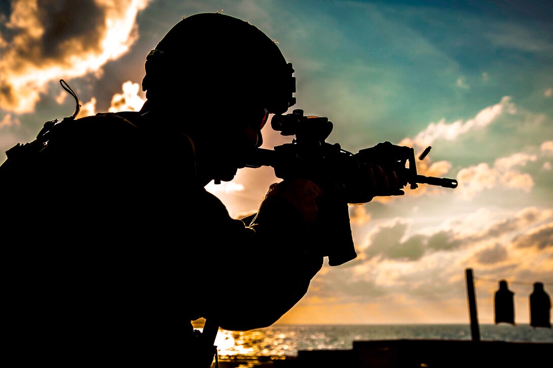 A Marine fires his weapon engaging a target.