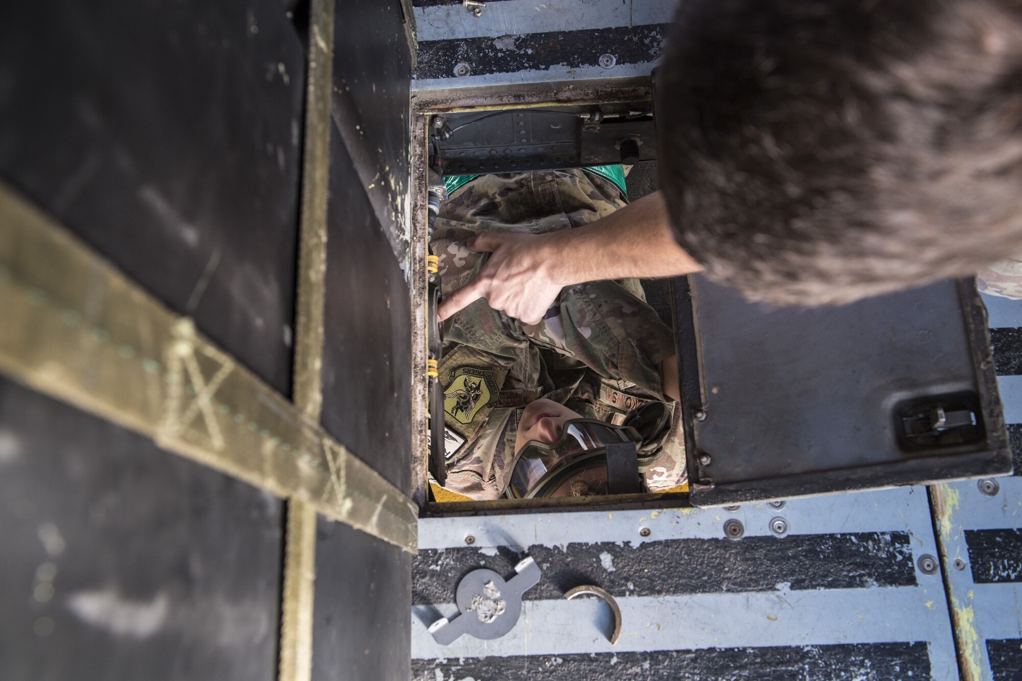 Airmen from the 723d Aircraft Maintenance Squadron discuss maintenance performed on a floor panel of an HH-60G Pave Hawk during an exercise, Dec. 5, 2017, at Moody Air Force Base, Ga. Moody’s Phase 1, Phase 2 exercise tested the 23d Wing’s ability to prepare, deploy and execute their mission at a moment’s notice. The 723d AMXS was tasked with folding HH-60s in preparation for transport in a larger aircraft and unfolding them once they arrive at their final destination. During folding, the rotor blades are revolved and aligned with the body of the helicopter, and fastened into place. (U.S. Air Force photo by Senior Airman Janiqua P. Robinson)