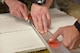 Senior Airman Adam Kresge, structural engineering journeyman with the 911th Civil Engineering Squadron, helps Airman 1st Class Joel Dennis to cut a piece of ceiling tile at the Pittsburgh International Airport Air Reserve Station, Dec. 3, 2017. Airmen like Kresge and Dennis maintain every structure on the base, thereby ensuring mission success. (U.S. Air Force photo by Staff Sgt. Marjorie A. Bowlden)