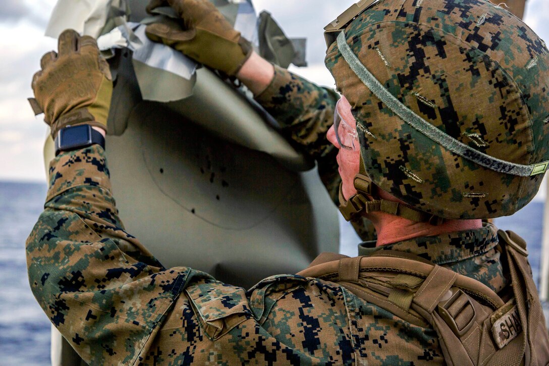 Marine Corps Cpl. Brett M. Shakofsky removes his target at the completion of combat marksmanship training.
