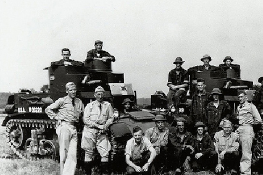 National Guard members pose with military vehicles in a black and white photo taken before World War II.