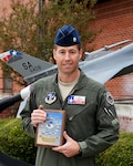 Lt. Col. Bryan Carlson, an F-16 Fighting Falcon instructor pilot assigned to the Air National Guard’s 149th Fighter Wing, poses with his 2017 High Flyer of the Year award (for F-16 pilots) at Joint Base San Antonio-Lackland, Kelly Field Annex, Texas, Nov. 30, 2017.