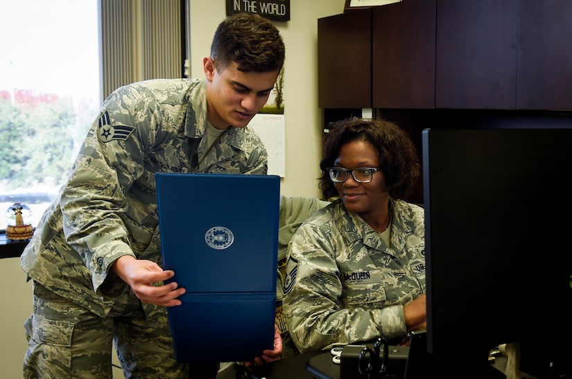 Senior Airman Ramon Santiago-Rosado, 437th Airlift Wing Executive Support Services administrator reviews an award package with Master Sgt. Denise McQueen, 437th AW Executive Support Services superintendent at Joint Base Charleston, S.C., Dec. 4, 2017