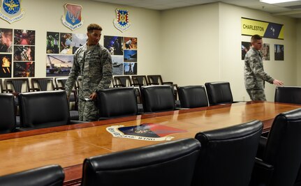Staff Sgt. Damien Chilton, 628th Air Base Wing Executive Support Services noncommissioned officer in charge, and Airman 1st Class Samuel Tyler, 628th ABW Executive Support Services administrator prepare the wing conference room at Joint Base Charleston, S.C., Dec. 4, 2017.