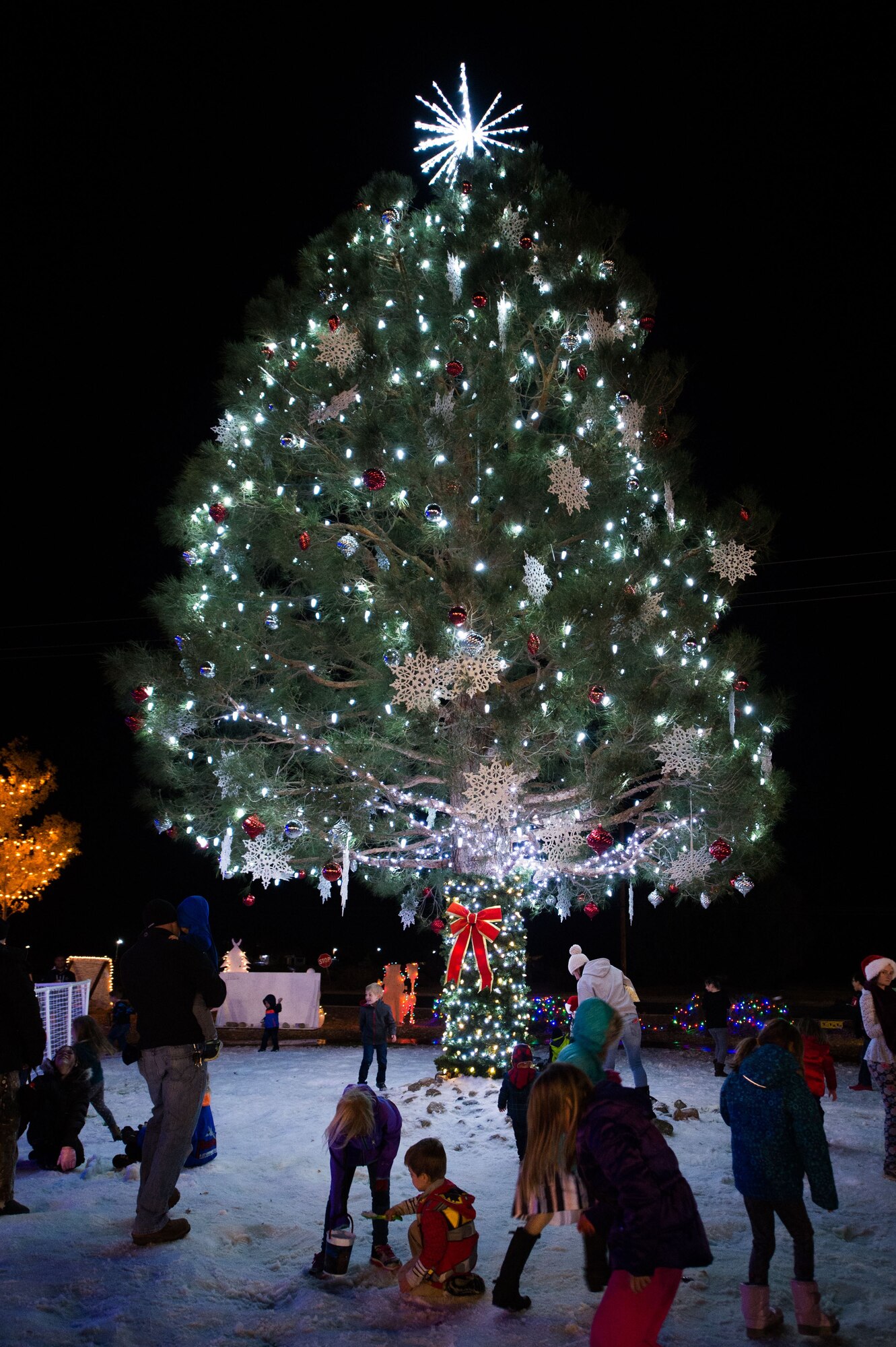 A holiday tree and 25 tons of man-made snow provide the centerpiece for Winterfest 2017, held at Edwards Air Force Base Dec. 1.  (U.S. Air Force photo by Jennifer Correa)