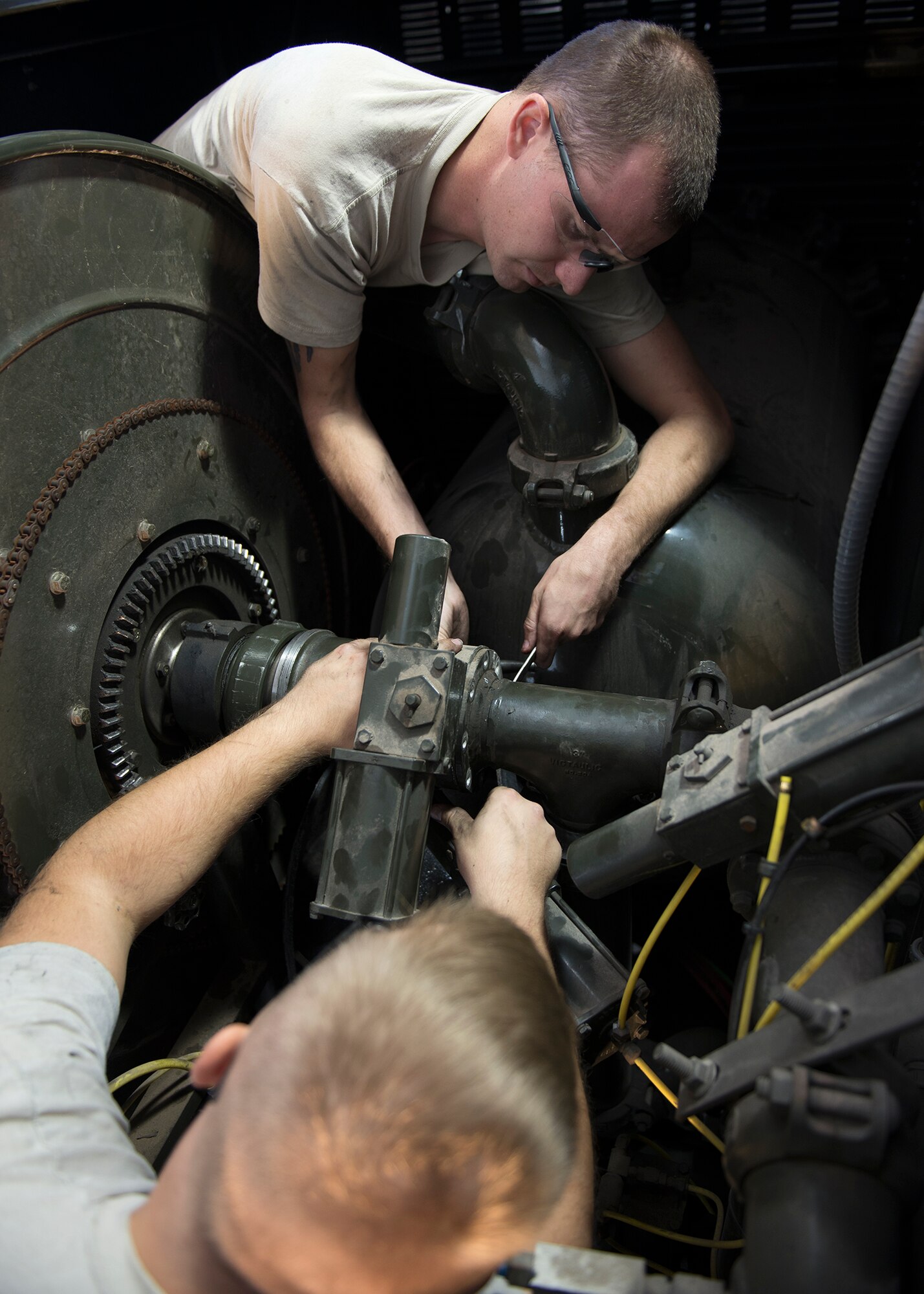Senior Airman Tyler Lee Bordner and Senior Airman Johnathan Bailey, 49th Logistics Readiness Squadron mission generating vehicle and equipment maintenance journeymen, separate the gasket on a butterfly valve at Holloman Air Force Base, N.M., Dec. 4, 2017. The shop is constantly working, whether it’s: replacing broken parts on a vehicle, diagnosing vehicle problems or general vehicle upkeep in support of Holloman’s mission. (U.S. Air Force photo by Staff Sgt. Timothy M. Young)