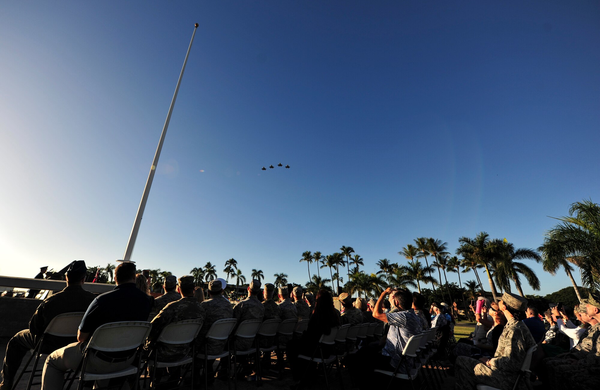 Spectators watch the F-22 Raptor missing man formation fly over during the 15th Wing’s Remembrance Ceremony, Joint Base Pearl Harbor-Hickam, Hawaii, Dec. 7, 2017. The 15th Wing sponsored the ceremony to remember the 76th anniversary of the attacks that claimed the lives of 189 Army Air Corps Airmen and civilians and injured 303 others. (U.S. Air Force photo by Tech. Sgt. Heather Redman)