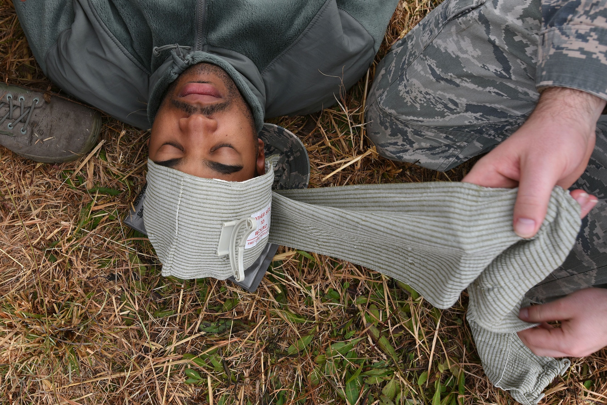 U.S. Air Force Senior Airman Nelson Blackshear, 20th Civil Engineer Squadron administrative journeyman, lies on the ground as his head is bandaged during self-aid buddy care (SABC) training at Poinsett Electronic Combat Range near Wedgefield, S.C., Dec. 5, 2017.
