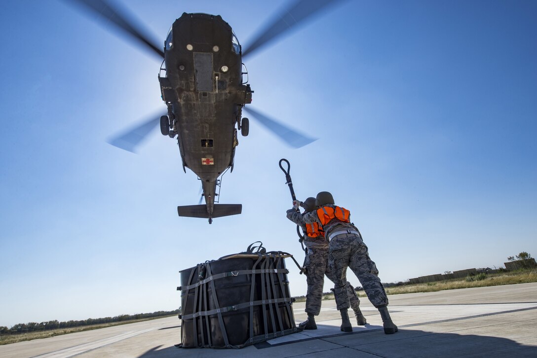 Airmen from the 26th Aerial Port Squadron attach a cargo bag with 2,000 pounds of relief supplies to the hook of a UH-60 Black Hawk helicopter flown by Texas Army National Guard Soldiers during Operation Alamo Evacuation at Martindale Army Airfield, Texas, Nov. 18, 2017. Approximately 36,000 pounds of cargo and 27 passengers were transported as part of the sling load and medical evacuation exercise. (U.S. Air Force photo by Senior Airman Stormy Archer)