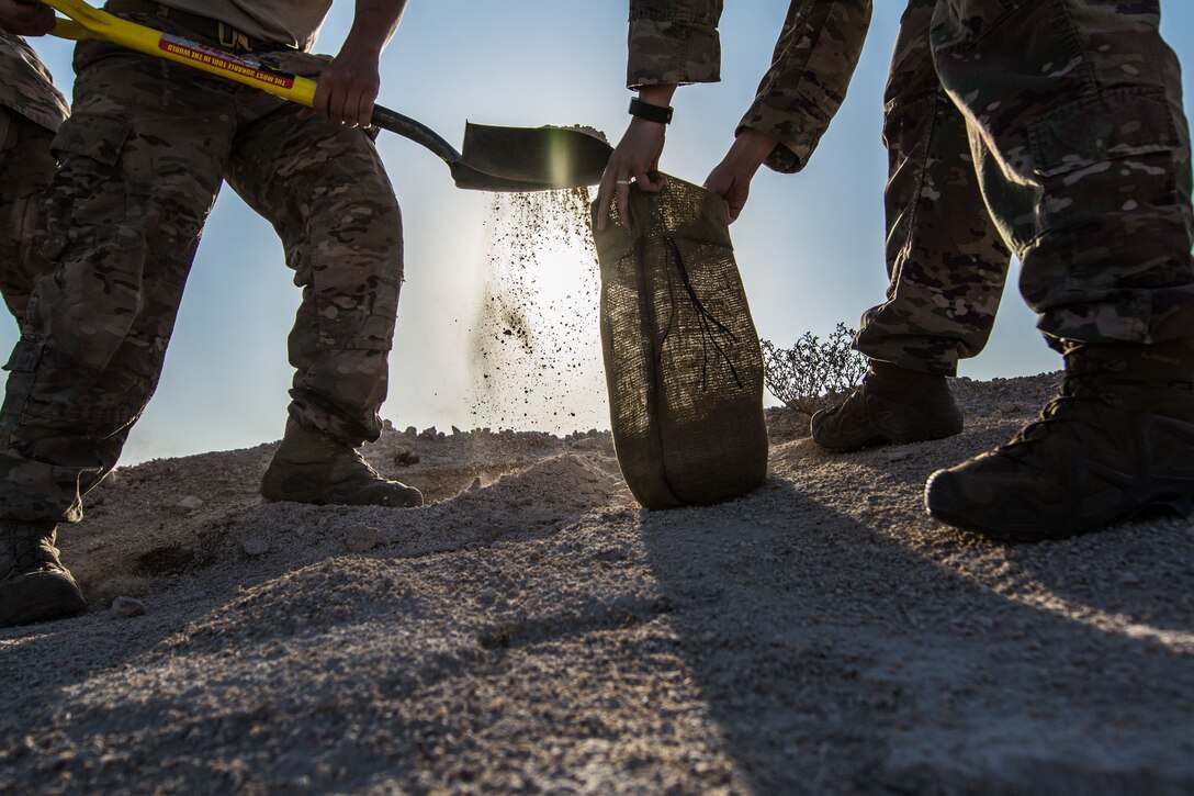 Airmen assigned to the 379th Expeditionary Civil Engineer Squadron fill sand bags during a joint chemical threat training exercise, Nov. 25, 2017, at Al Udeid Air Base, Qatar. The sandbags were used to secure munitions while explosive ordnance disposal technicians were assessing them. (U.S. Air National Guard photo by Staff Sgt. Patrick Evenson)