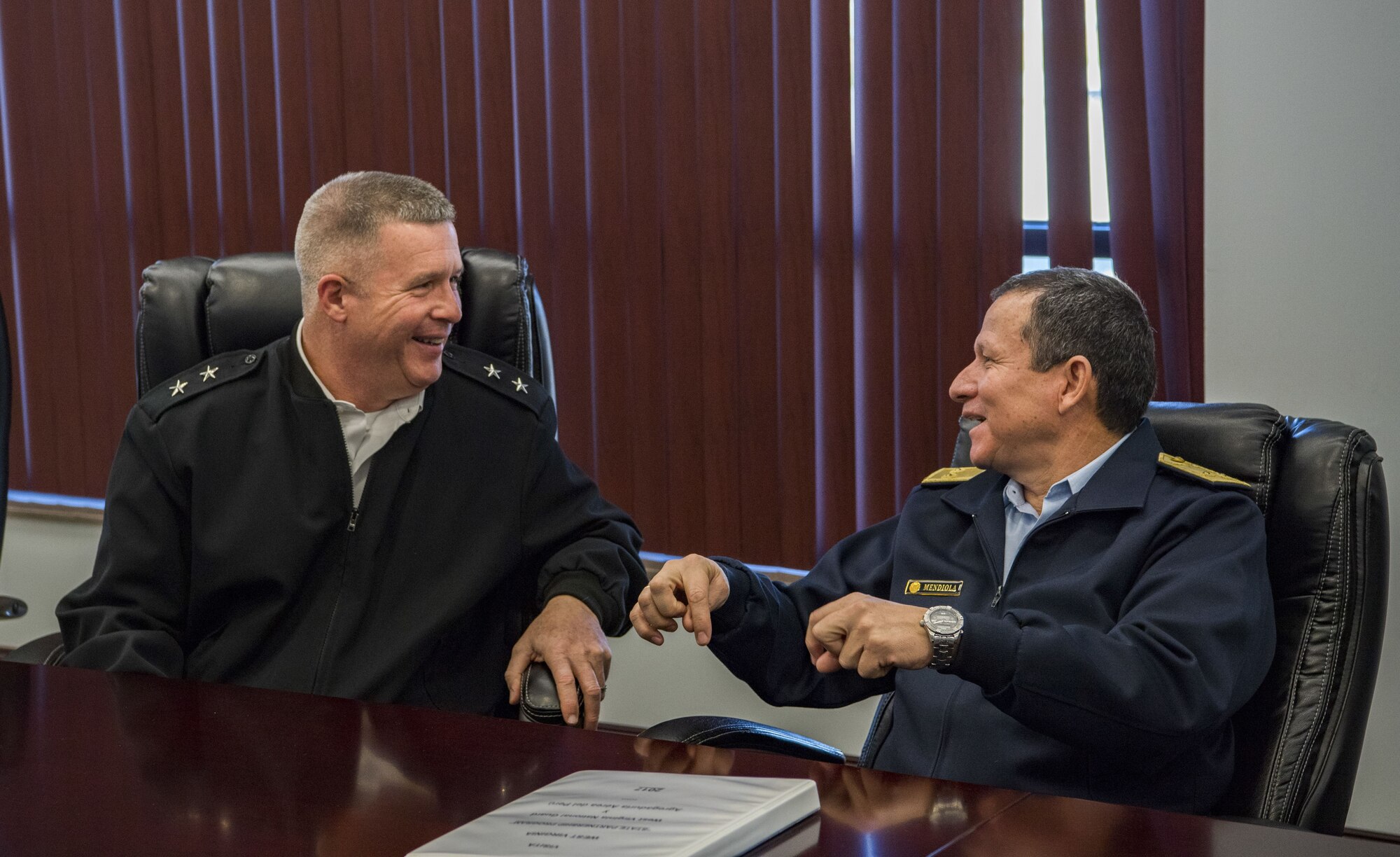U.S. Army Maj. Gen. James A. Hoyer, the Adjutant General of the West Virginia National Guard, shares a laugh with Peruvian Air Force Maj. Gen. Gregorio C. Mendiola, Assistant Defense and Air Attaché for the Embassy of Peru, while discussing ways in which the West Virginia National Guard and the country of Peru’s military can extend their partnership Nov. 21, 2017 at McLaughlin Air National Guard Base, Charleston, W.Va. The State Partnership Program (SPP) is designed to build and improve relations around the globe through 73 security partnerships with different countries, including Peru as West Virginia’s partner. (U.S. Air National Guard Photo by Airman Caleb Vance)